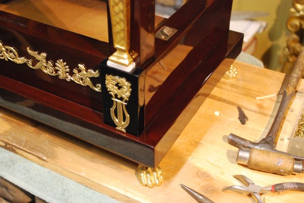 Restaurierung: Aufnageln der Messingornamente Flötenuhr Empire